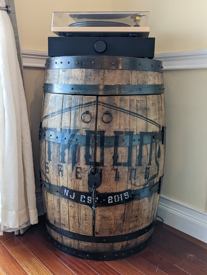 Commissioned whiskey barrel displayed in customer's home- frontal view with doors closed.