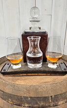 Load image into Gallery viewer, A whiskey barrel stave coaster sporting 3 indents, with a Glencairn glass at each end, and a small carafe in the middle.  The coaster sits on a barrel top. A whiskey decanter sits behind the coaster and the glasses hold whiskey and water.
