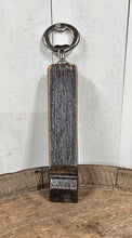 Load image into Gallery viewer, Whiskey barrel stave handled bottle opener, standing on top of a whiskey bottle. Shows the back of the opener.
