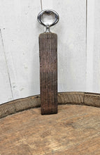 Load image into Gallery viewer, Whiskey barrel stave handled bottle opener, standing on top of a whiskey bottle.  Shows the front of the opener.
