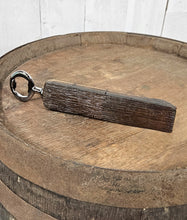 Load image into Gallery viewer, Whiskey barrel stave handled bottle opener, laying on top of a whiskey bottle. Shows the front of the opener.
