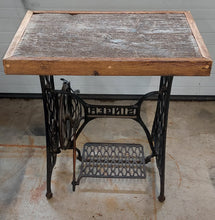 Load image into Gallery viewer, A barnboard tabletop affixed to a Singer sewing machine stand. 
